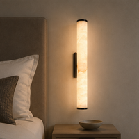 Marmeren wandlamp naast een hoofdeinde van een bed, boven een nachtkastje met een lichte schaal. 9