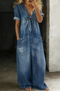 Voorkant in donkerblauwe denim, gedragen door een model, met strik, V-hals en opgerolde mouwen 1