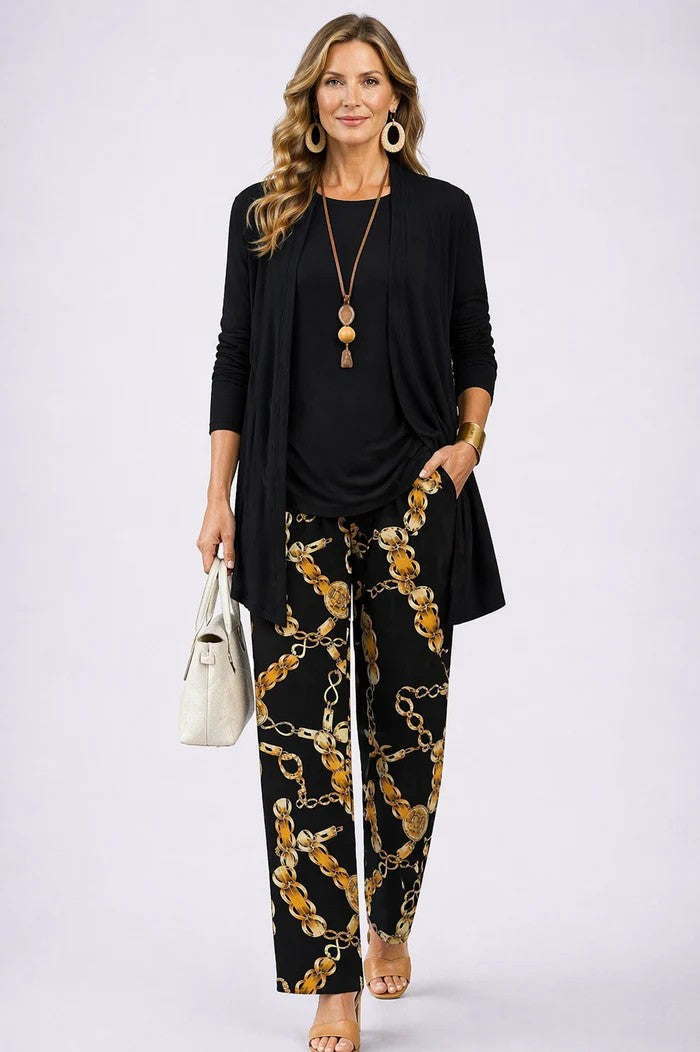 Model in zwart effen vest en top met wijde broek met gouden kettingprint 10
