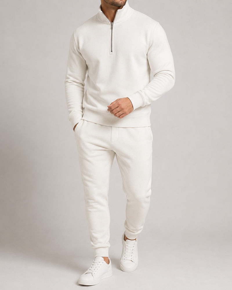 Witte uitvoering op model, halfziptrui met ritskraag en joggingbroek met boorden, gecombineerd met witte sneakers 4