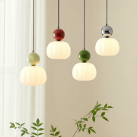 Vier verlichte hanglampen met geribbelde witte kap en gekleurde bol in lichtgroen, rood, groen en chroom 1