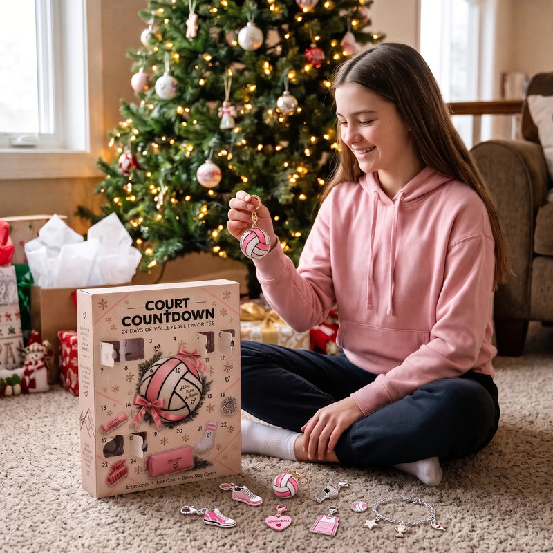Meisje in roze hoodie houdt een volleybalbedeltje vast bij de doos en kerstboom 1