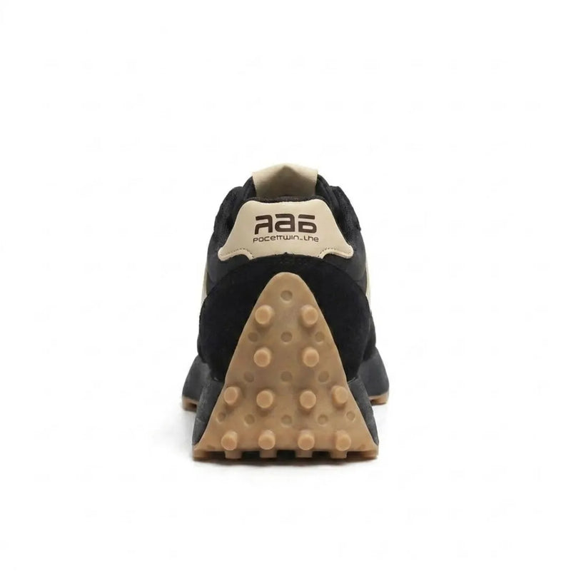 Zwarte sneaker van achteren, met beige hielstrook en driehoekige bruine noppenzool 20