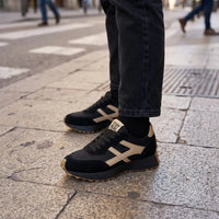 Zwarte sneakers met beige details gedragen met zwarte spijkerbroek en sokken op straat 17