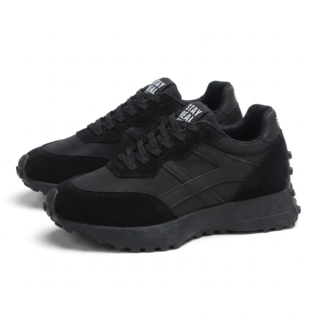 Paar zwarte sneakers met veters en plateauzool, schuin vooraanzicht op witte achtergrond 8