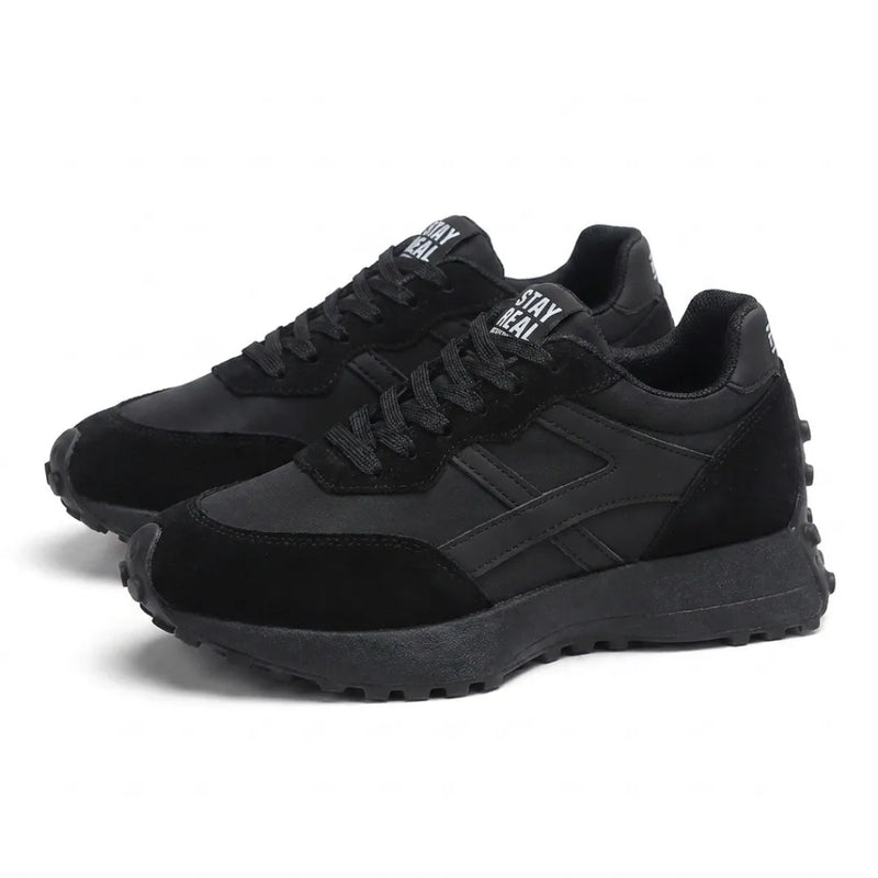 Paar zwarte sneakers met veters en plateauzool, schuin vooraanzicht op witte achtergrond 8