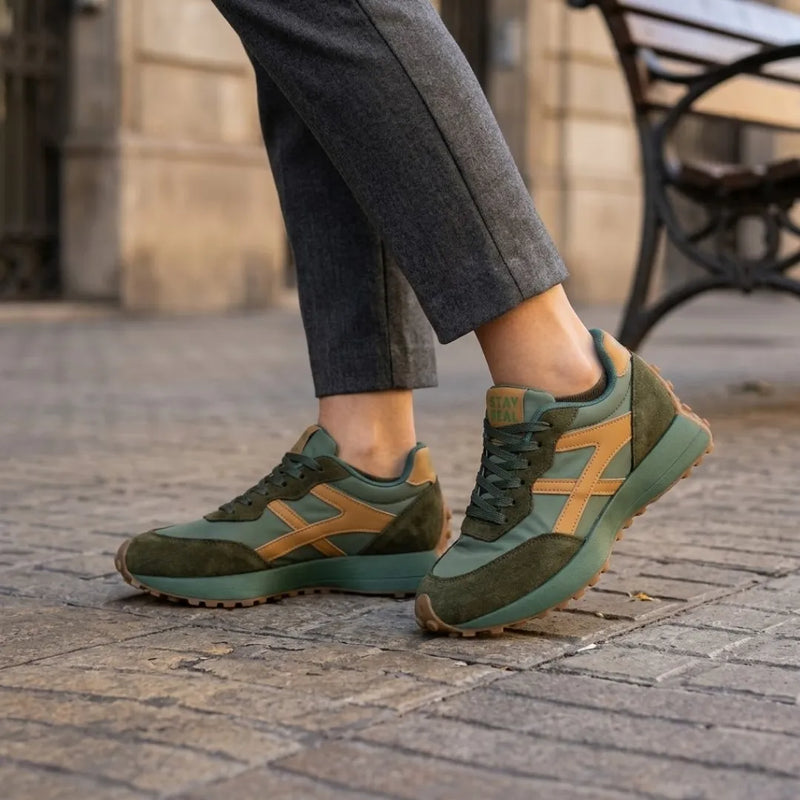 Groene sneakers met okergele details gedragen met grijze pantalon op een straat 12