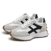 Paar sneakers schuin van voren op een witte achtergrond, met witte veters en zwarte details 23
