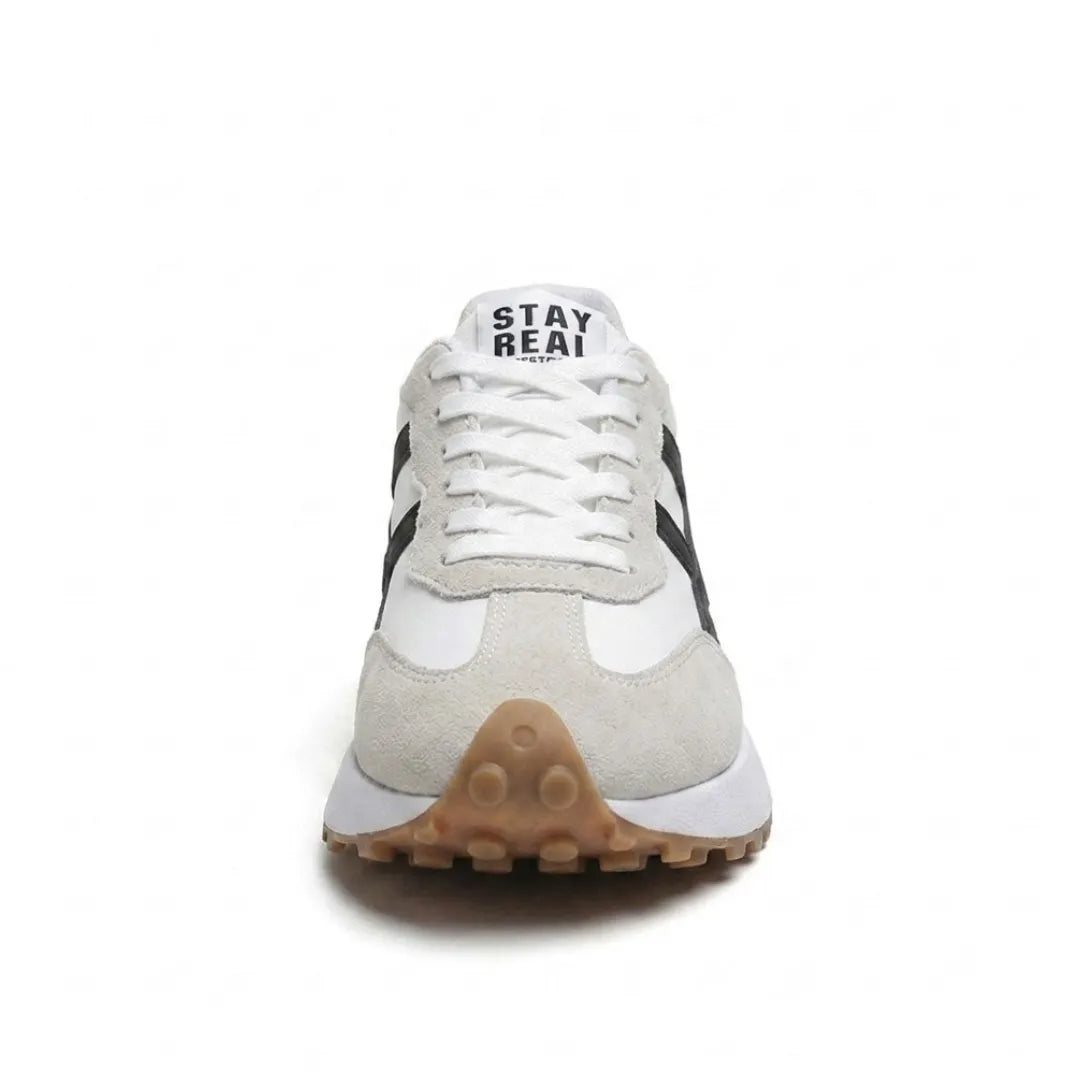 Voorkant van de sneaker met witte veters, grijs suède neusstuk en bruine noppenzool 24