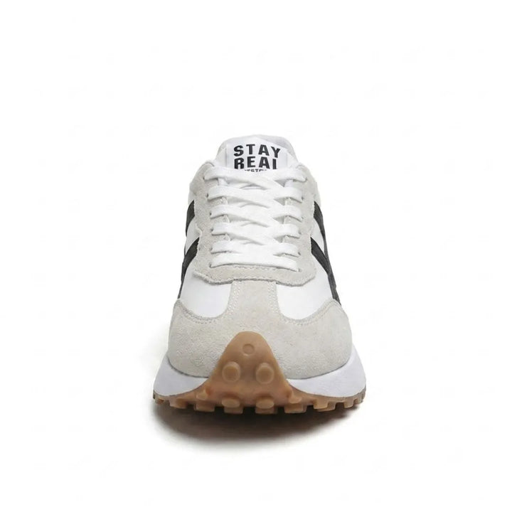 Voorkant van de sneaker met witte veters, grijs suède neusstuk en bruine noppenzool 24