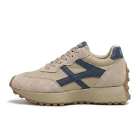 Beige sneaker met donkerblauwe zijstreep, zijaanzicht met dikke plateauzool en noppenprofiel 1