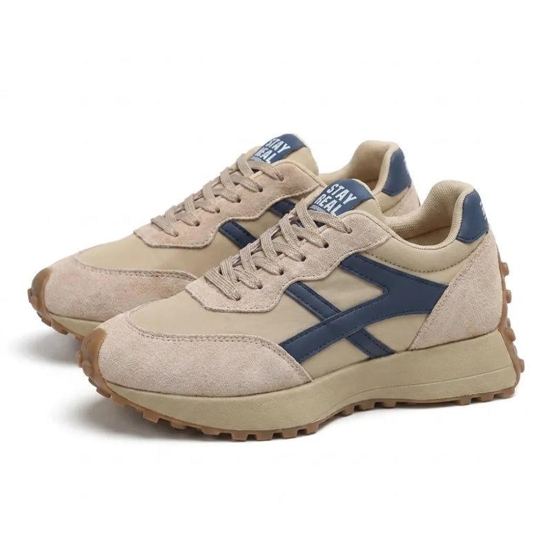 Paar beige sneakers met blauwe accenten en veters, schuin vooraanzicht op witte achtergrond 3