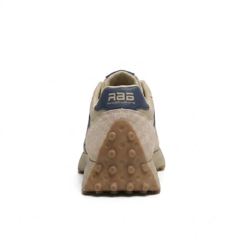 Beige sneaker van achteren, met blauwe hielstrook en driehoekige zool met noppen 5