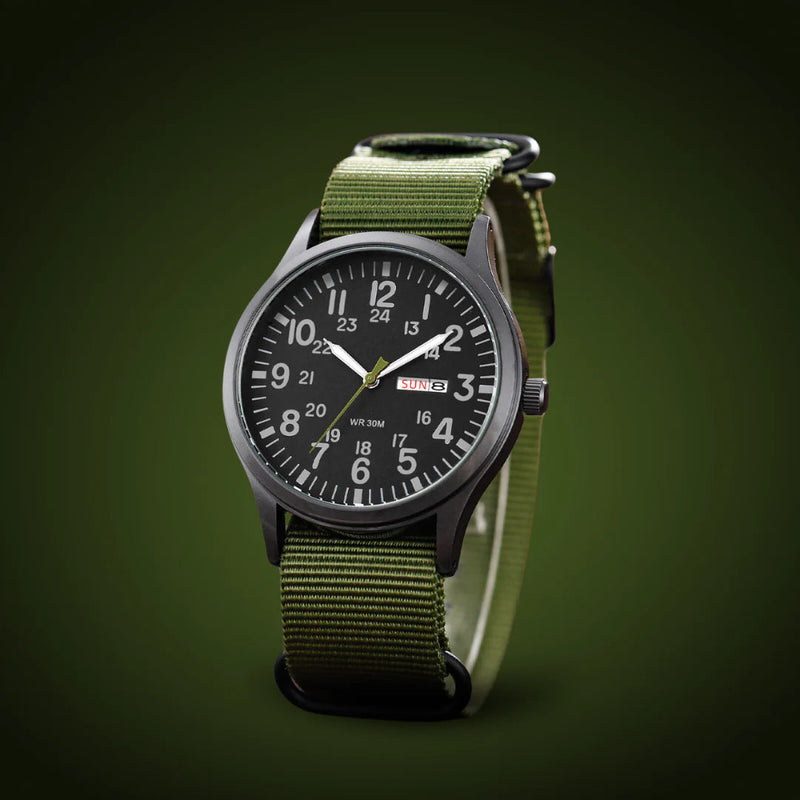 Schuin gefotografeerd horloge met legergroene geweven band en zwarte wijzerplaat tegen een donkergroene achtergrond. 4