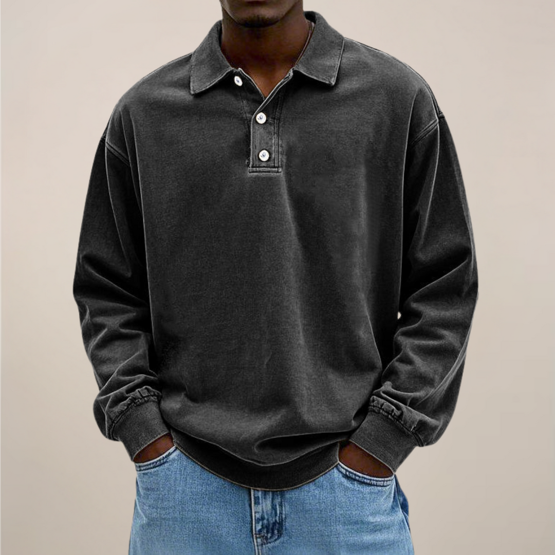 Model draagt de losse polo met lange mouwen en knoopsluiting in zwart, gecombineerd met een lichtblauwe spijkerbroek. 8