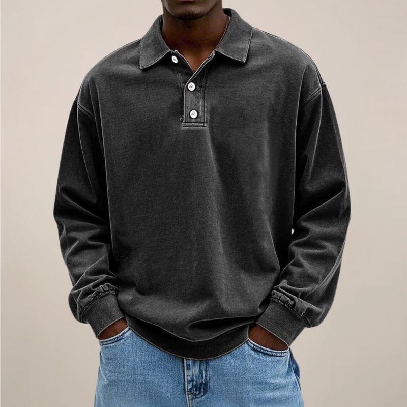 Model draagt de losse polo met lange mouwen en knoopsluiting in zwart, gecombineerd met een lichtblauwe spijkerbroek. 8