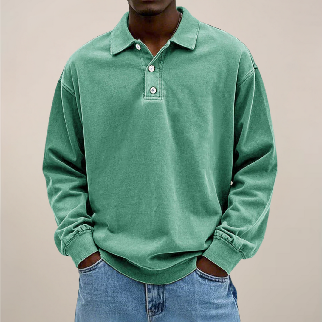 Model draagt de losse polo met lange mouwen en knoopsluiting in mintgroen, met handen in de zakken van een spijkerbroek. 9