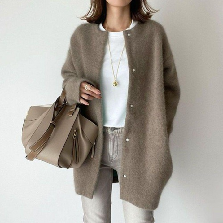 Model draagt het vest in taupe met drukknopen, wit shirt en lichtgrijze jeans 7
