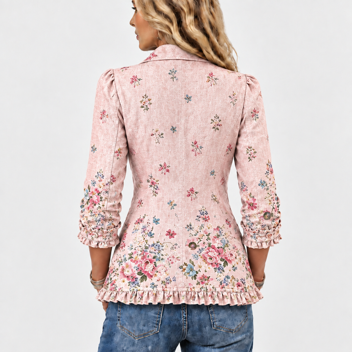 Achterkant van het roze jasje met verspreide bloemenprint, driekwartmouwen met ruches en een geruchte onderrand. 5