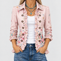 Close-up van het roze jasje met bloemenprint, ruches langs de open voorkant en knopen, gedragen over wit topje en jeans. 1