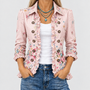Close-up van het roze jasje met bloemenprint, ruches langs de open voorkant en knopen, gedragen over wit topje en jeans. 1