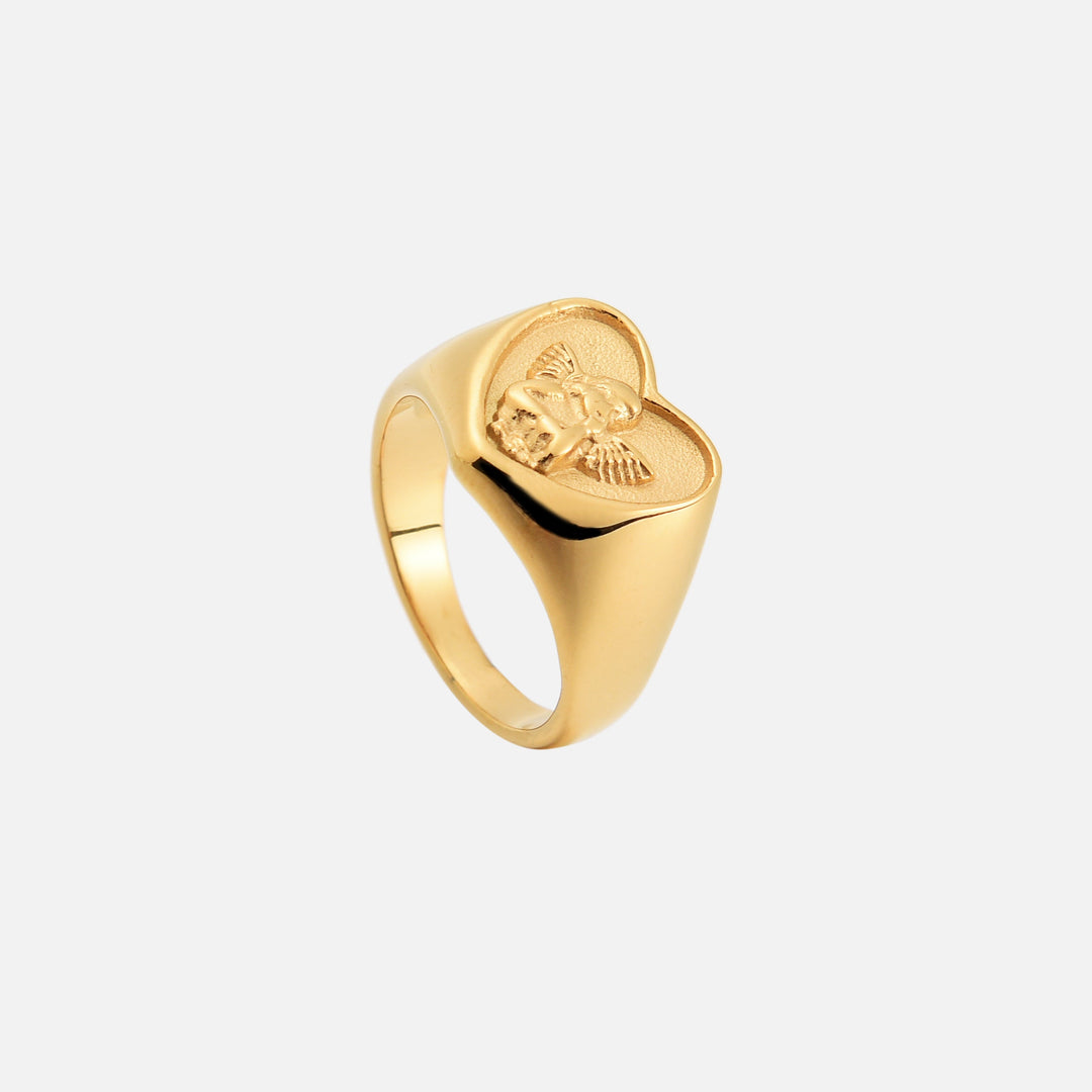 Dezelfde gouden hartring van boven en schuin gezien, met het engeltje in reliëf en de gladde ringband. 2