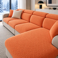 Oranje gestructureerde hoezen op een hoekbank met chaise longue en twee kussens, in een winterse woonkamer 1