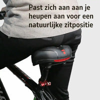 Fietser in grijze trui zit op het zadel, gezien van achteren, met rode reflector aan de achterkant. 6