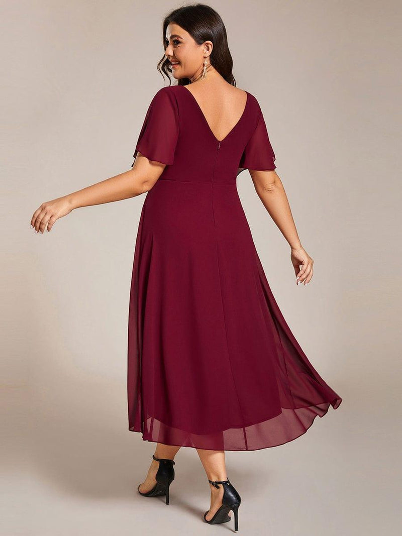 Achterkant van de bordeauxrode jurk met diepe V-rug en ritssluiting, model kijkt over haar schouder. 50