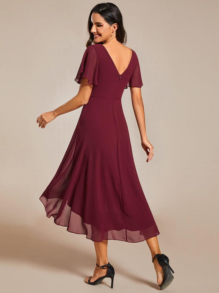 Bordeauxrode jurk van achteren, met V-rug, rits en asymmetrische chiffon zoom, gedragen met zwarte hakken 4