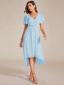 Model in lichtblauwe chiffon jurk met gekruiste V-hals en korte fladdermouwen, loopt naar voren in witte sandalen. 84