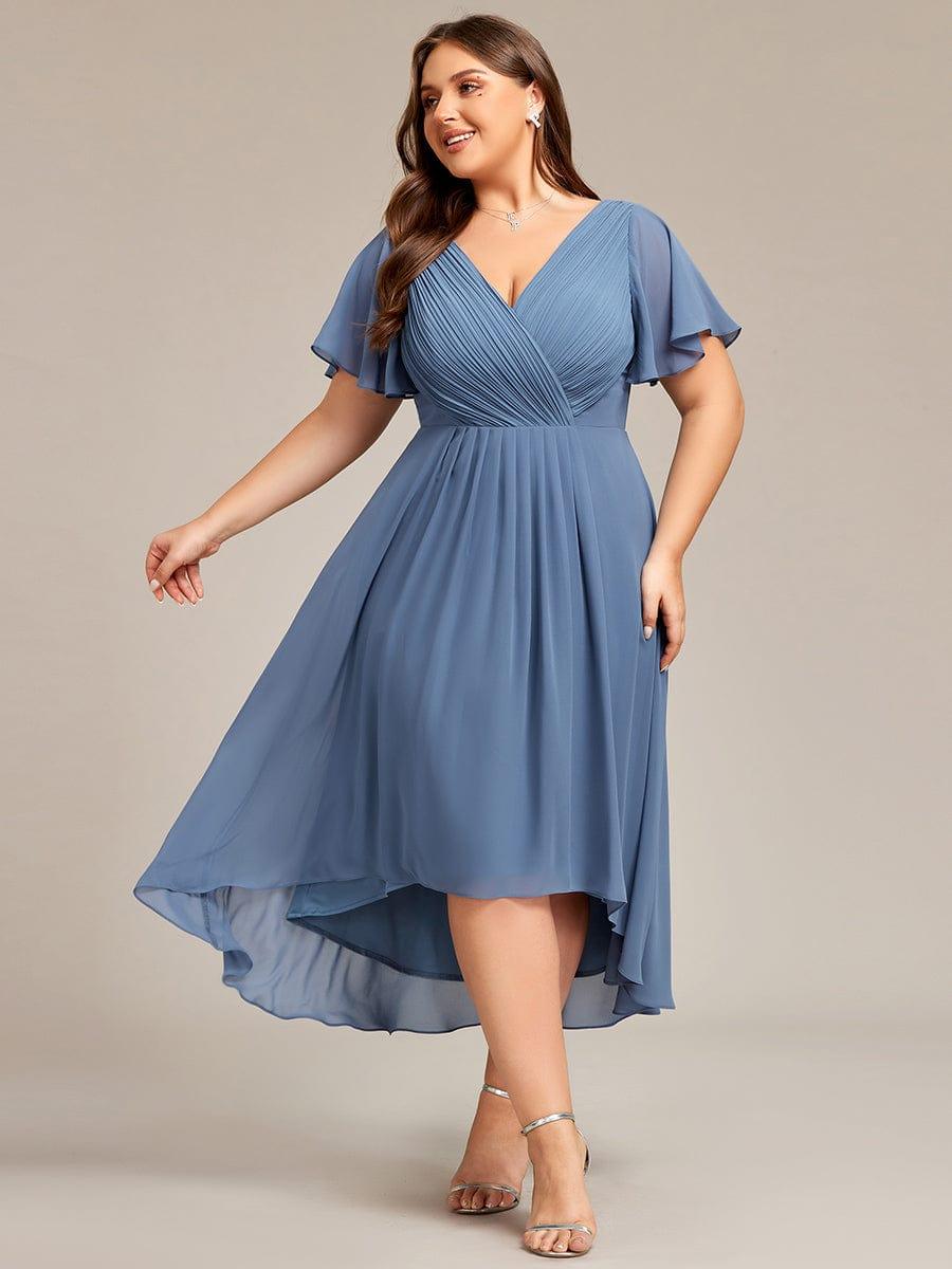 Model in grootte-ruime dusty blauwe chiffon jurk met V-hals, wijde mouwtjes en asymmetrische zoom, lachend in beweging. 41