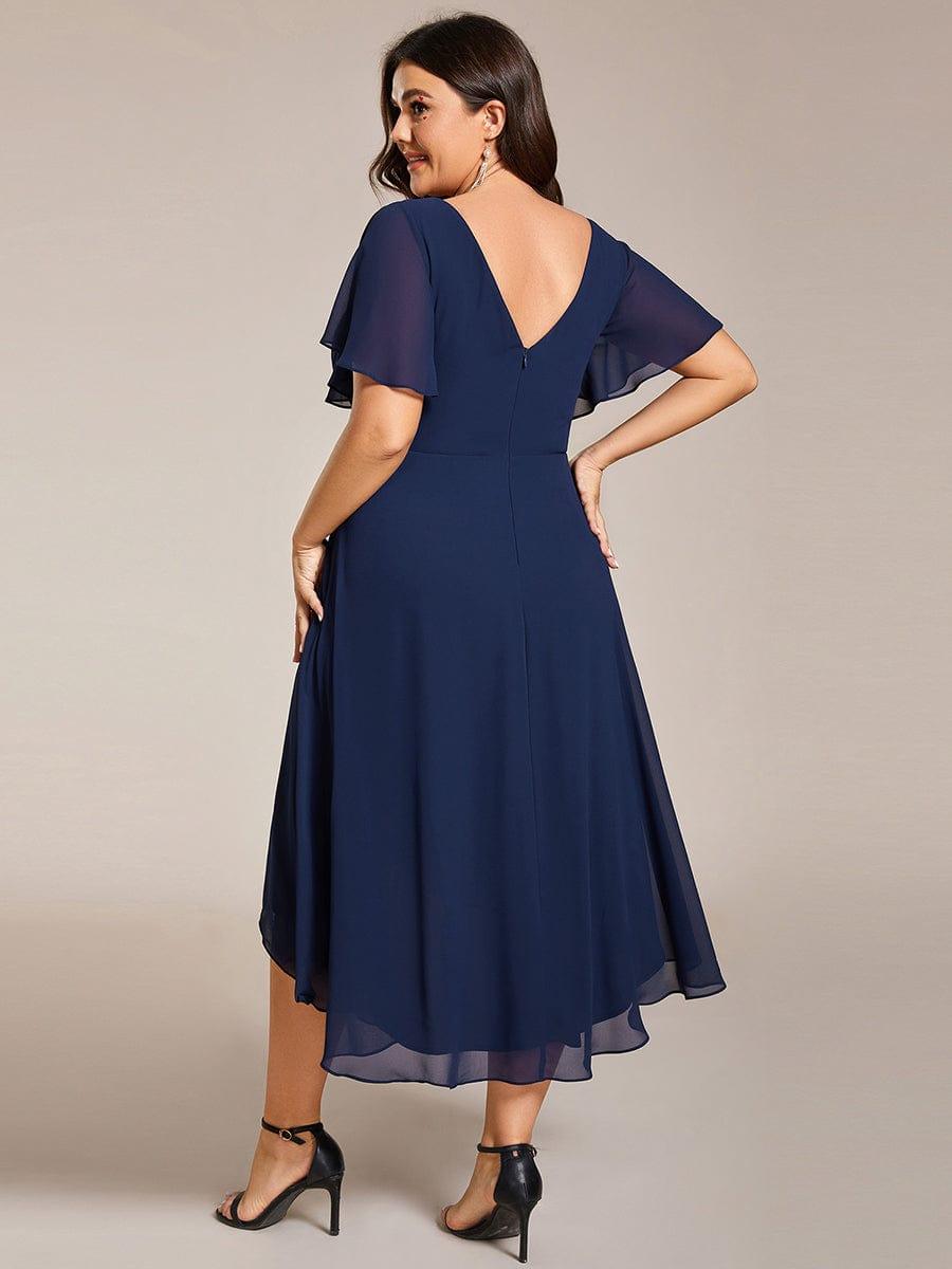 Achterkant van de marineblauwe jurk met diepe V-rug en ritssluiting, model kijkt over haar schouder. 56