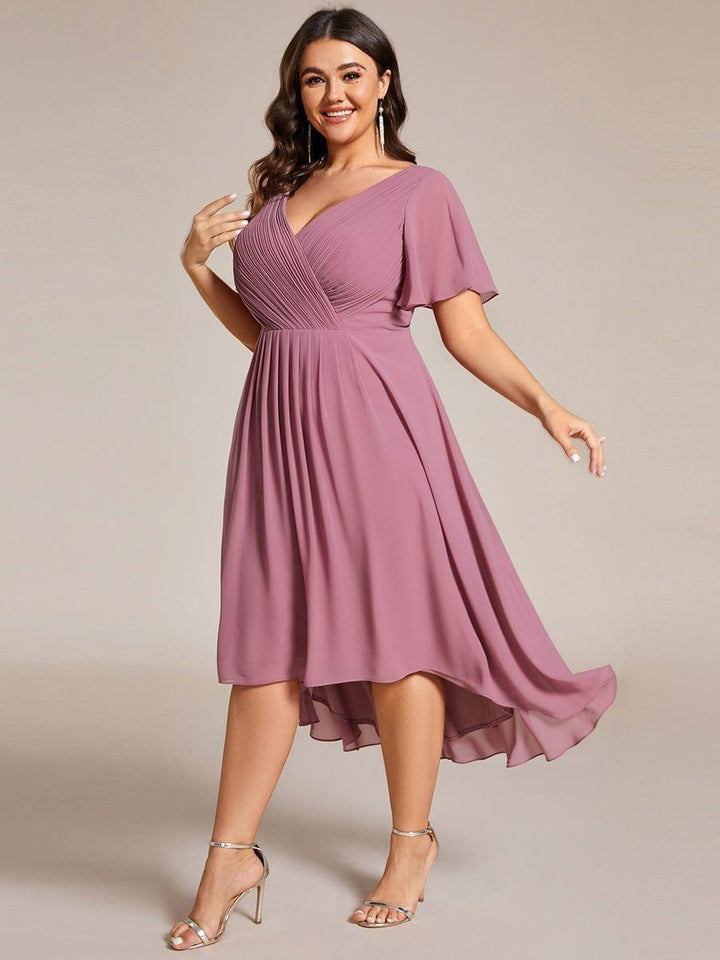 Model met maatje meer draait in de oudroze jurk, waardoor de asymmetrische chiffon zoom zwierig meebeweegt. 67