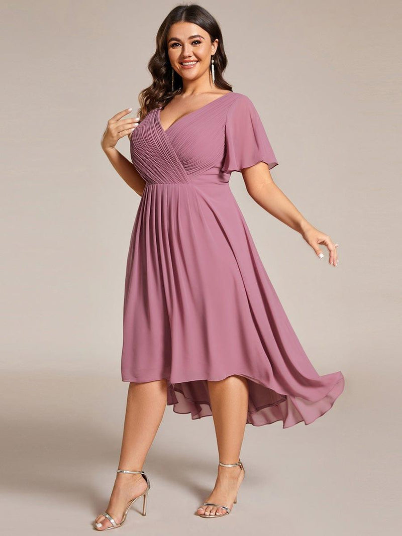 Model met maatje meer draait in de oudroze jurk, waardoor de asymmetrische chiffon zoom zwierig meebeweegt. 67