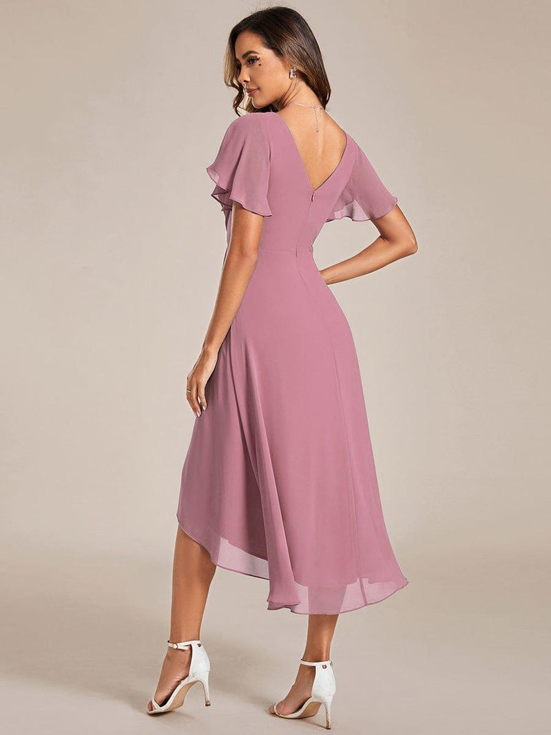 Achterkant van de oudroze jurk met diepe V-rug, ritssluiting en lopende asymmetrische zoom, gedragen door een model. 59