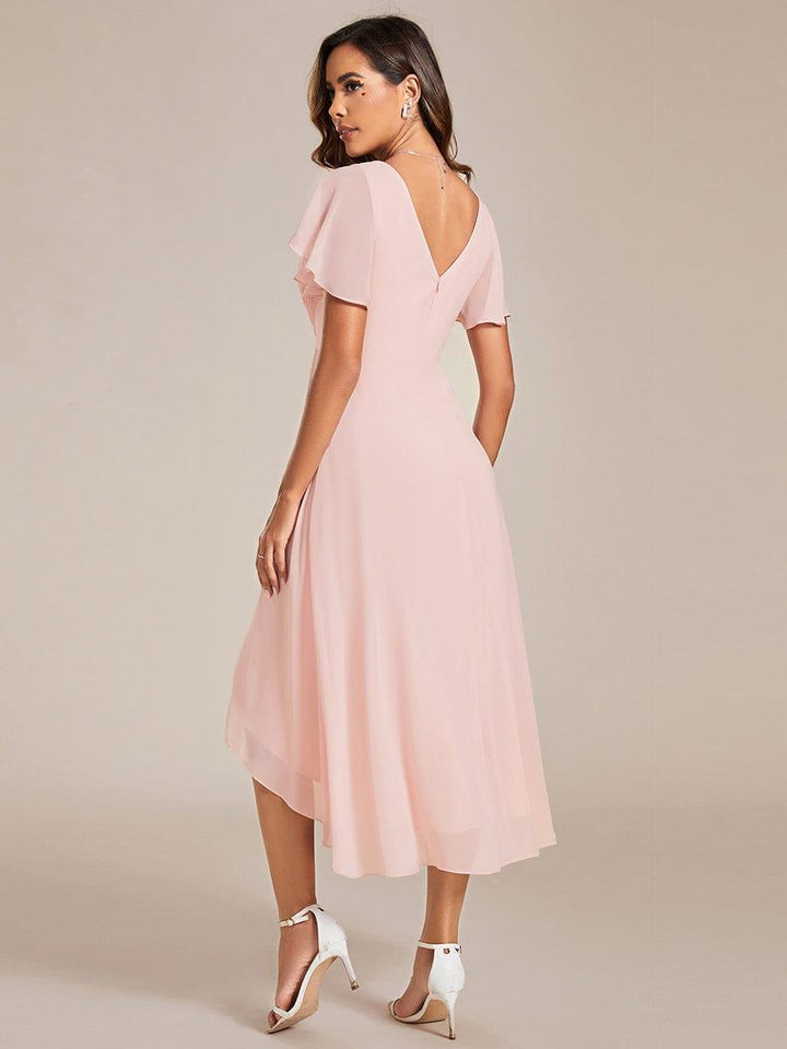 Roze jurk van achteren, met diepe V-rug, rits en asymmetrische chiffon zoom, gedragen met witte hakken 16
