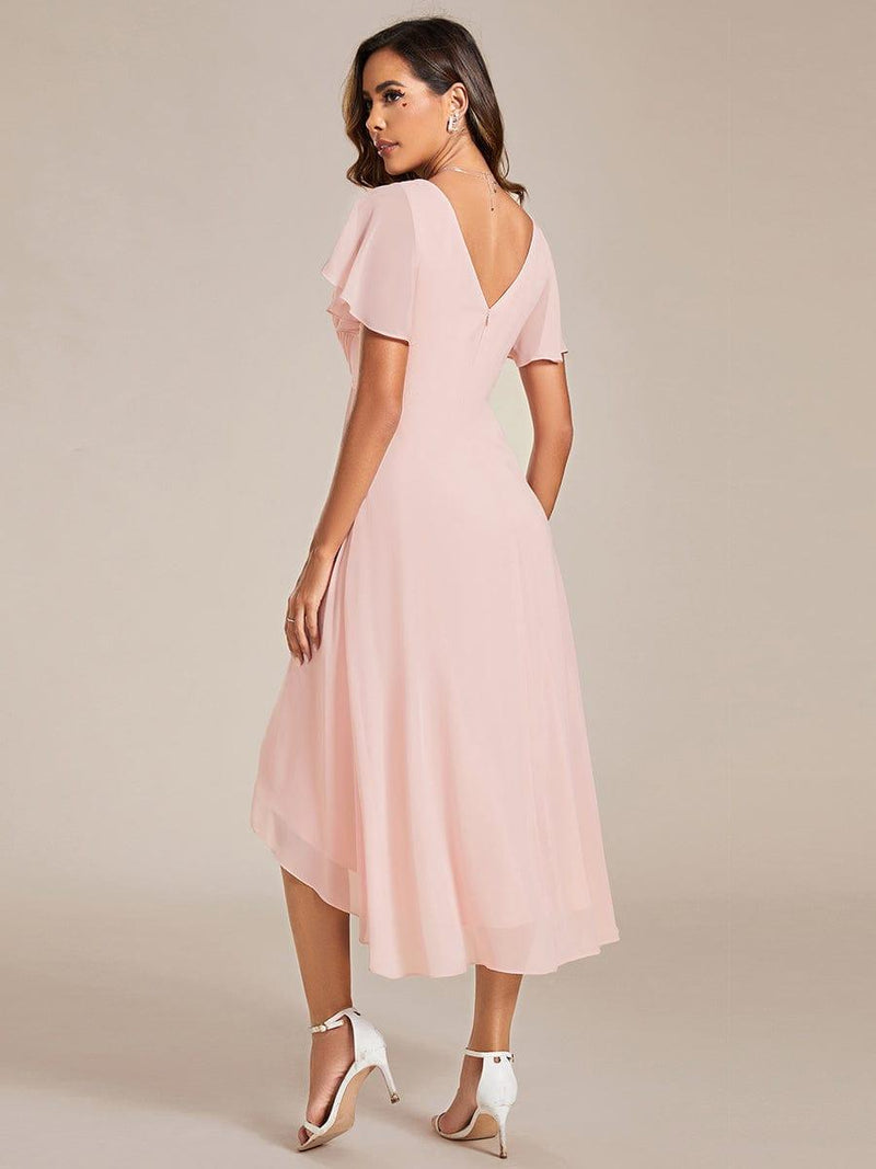 Roze jurk van achteren, met diepe V-rug, rits en asymmetrische chiffon zoom, gedragen met witte hakken 16