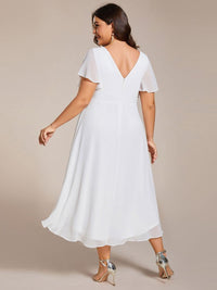 Achterkant van de witte jurk bij een model met maatje meer, met diepe V-rug en ritssluiting. 74
