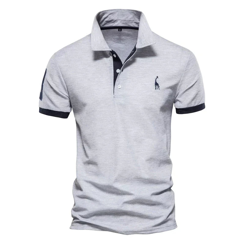 Lichtgrijs poloshirt met donkerblauwe mouwboorden en knoopstrook, een geborduurde giraf en een nummer op de mouw 4