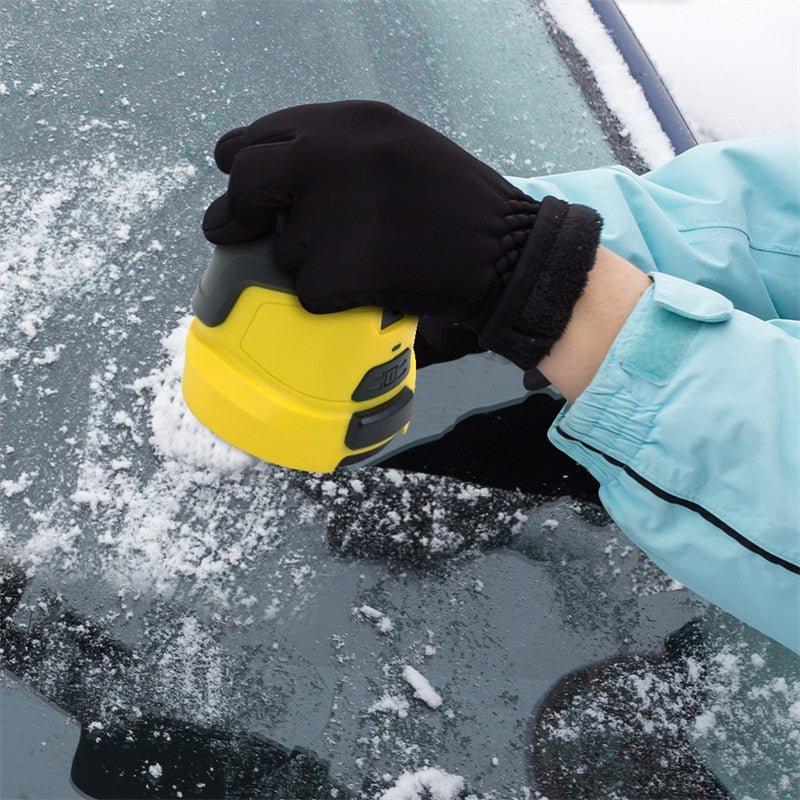 Hand met zwarte handschoen houdt de gele krabber op een met sneeuw bedekte autoruit 4