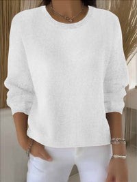 Witte gebreide trui met ronde hals, gedragen door een model met sieraden en een witte broek 3