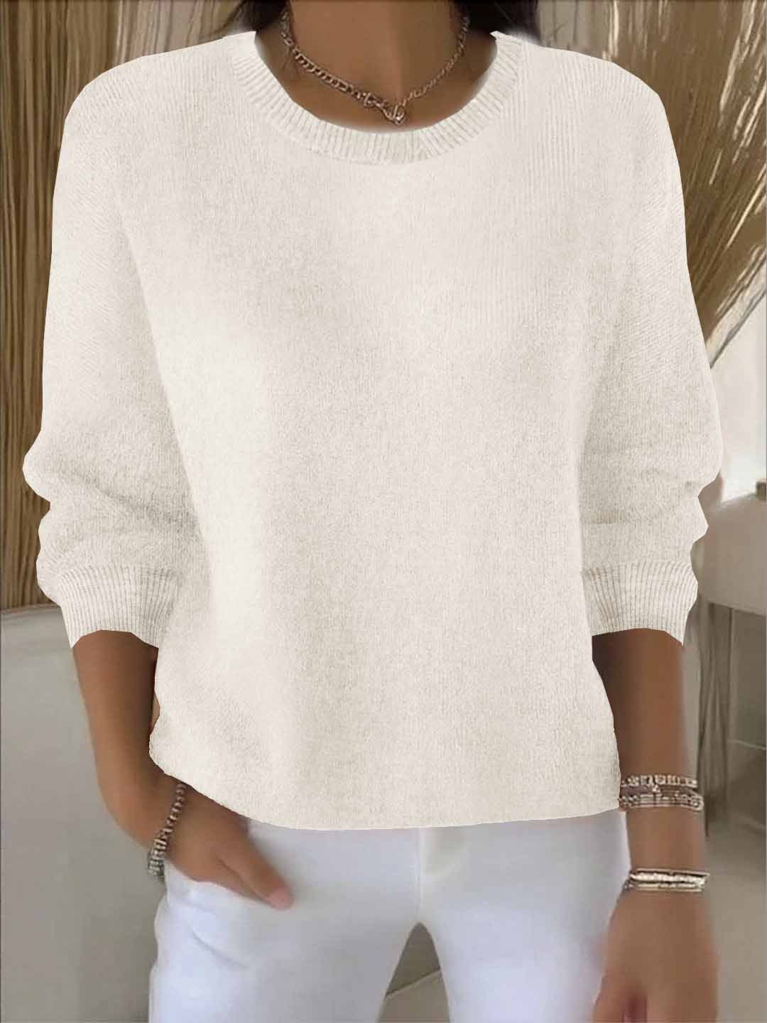 Crèmekleurige gebreide trui met ribboord, gedragen door een model met een witte broek 4