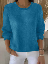 Turquoiseblauwe gebreide trui met ribboord, gedragen door een model met een witte broek 12