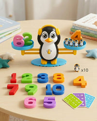 Pinguïnbalans met koptelefoon op een ronde tafel, omringd door losse cijfers, kaarten en een pinguïnfiguurtje 9