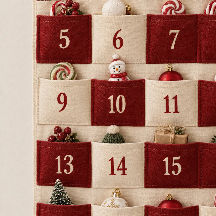Close-up van de vakjes 5 tot en met 15 met de grove stofstructuur, stiksels en kleine kerstfiguurtjes die uit de zakjes steken. 3