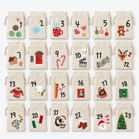Complete set van 24 genummerde zakjes met kerstprintjes, netjes in zes kolommen en vier rijen op een lichte achtergrond gelegd. 2