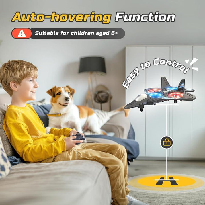 Jongen op een bank bedient met een controller het zwevende vliegtuig boven een landingsplaats, terwijl een hond toekijkt. 6