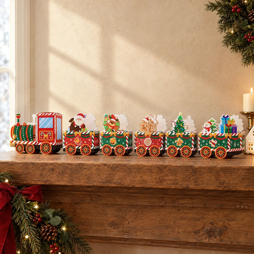 Gekleurde kartonnen kersttrein met locomotief en vijf wagons met kerstfiguren, opgesteld op een houten schouw naast dennentakken en een kaars. 1