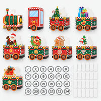 Alle losse onderdelen op een rij: locomotief, cabine, wagons met kerstfiguren, vel met nummerstickers van 1 tot 24 en witte plakvlakjes. 2